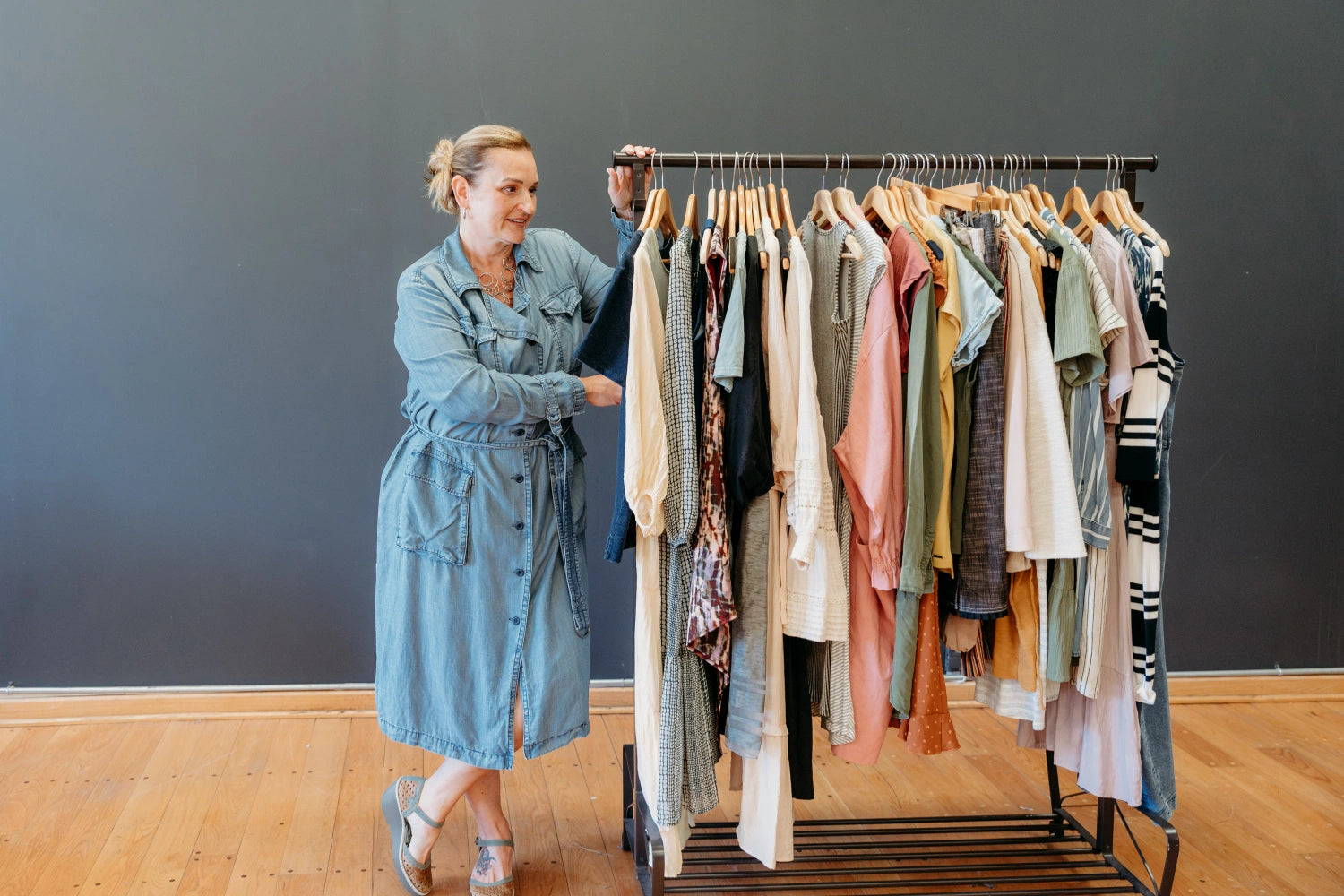 Raquel of The Reloved Boutique in Hamilton standing next to a rack of women's clothing