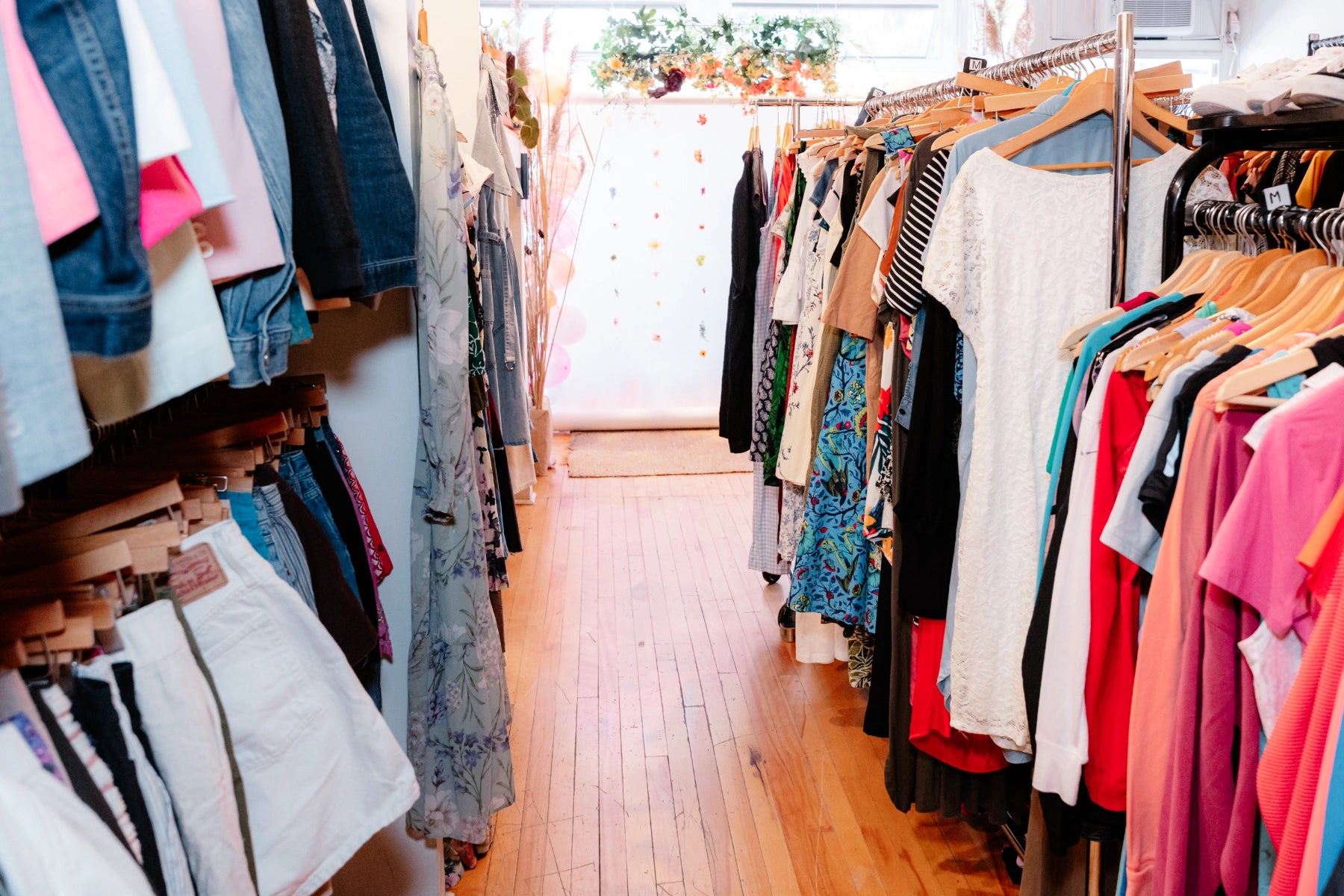 Racks of clothes on a wooden floor at the Reloved Boutique